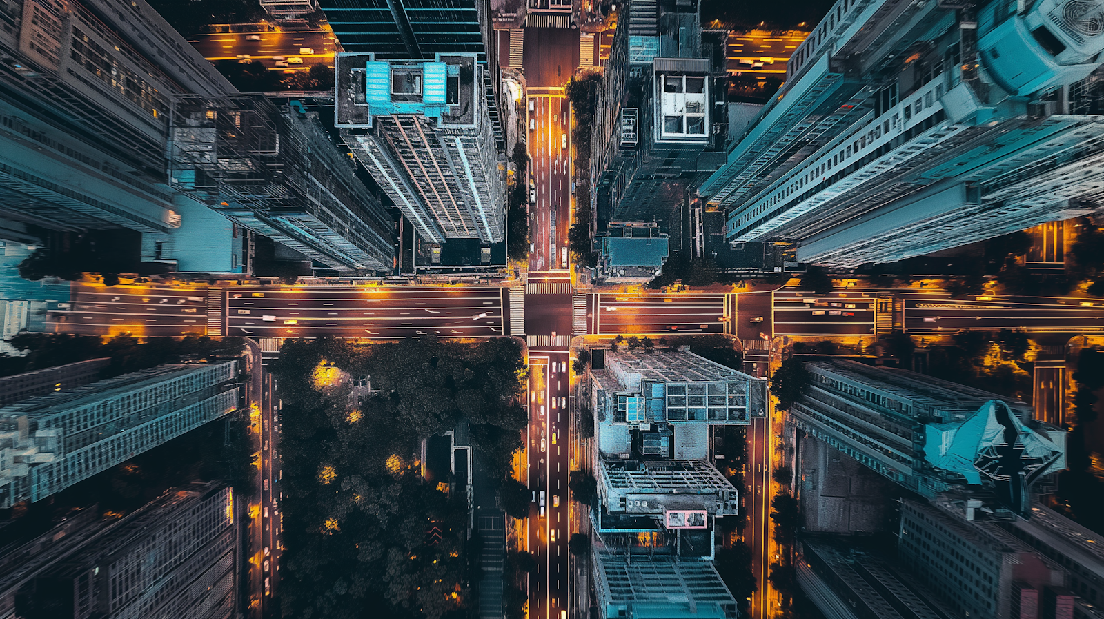 City blocks at night seen from directly above, streets lit in a grid