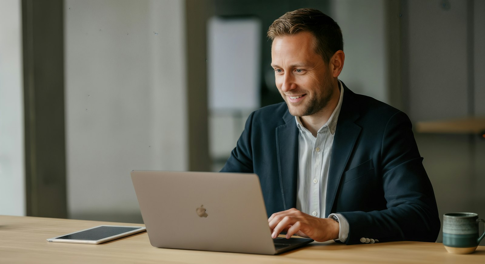 A smiling professional working on a laptop