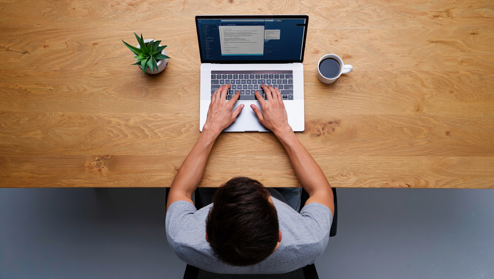 Overhead view of a person typing on a laptop